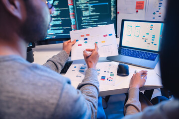 Asian software developers teams working on multiple screens displaying code and application...