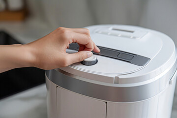 Woman is setting the timer on a bread maker, ready to bake a fresh loaf at home