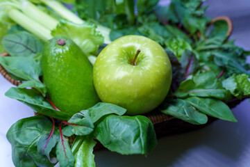A beautiful still life consisting of a green apple ripe avocado and fresh herbs