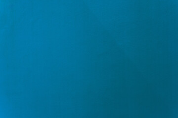 Light navy blue color paint on cement wall texture as background.