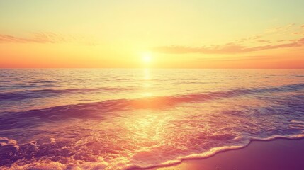 Obraz premium A soft, hazy sunset over a calm ocean with waves gently lapping at the sandy shore.