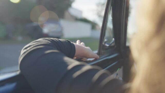 Woman sitting by driver on a right-hand drive vehicle while riding on a road. Driving on sunny day in Sydney Australia female has her arm on the convertible car window. Classic vintage car close up