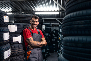 Portrait of smiling male worker standing in tire service warehouse.