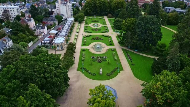 Drone flying over Thabor gardens with fountains and flower beds, Rennes in France. Aerial drone backward