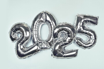 2025 Silver Balloon Numbers on blue background. Festive New Year Celebration Theme