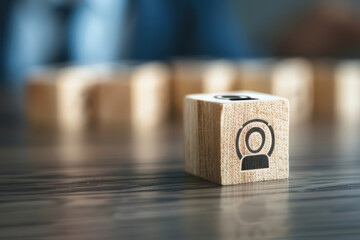 Hand stacking wooden blocks with icons representing teamwork, leadership, and business strategy, symbolizing organizational development and success.