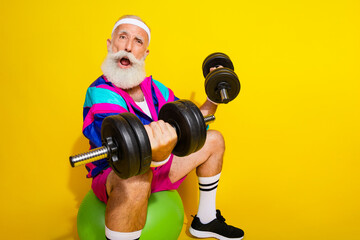 Photo portrait banner of funny senior sportsman lifting weights dressed stylish retro sport costume isolated on yellow color background