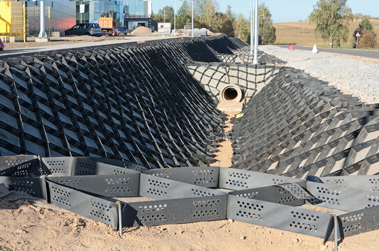 Landscaping of slope at construction site. Plastic geogrid for strengthening soil and slopes. City and plant, favorable environmental conditions. 