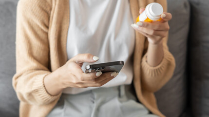 Asian woman Search for information on Internet in smartphone with holding bottled drug. girl reading information online on mobile phone medicine healthcare product concept.