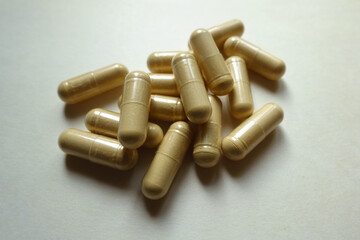 Heap of beige capsules of Saccharomyces boulardii probiotic dietary supplement