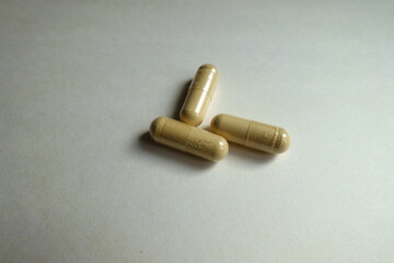 Close shot of three beige capsules of Saccharomyces boulardii probiotic dietary supplement