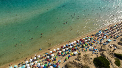 Aerial view of the public beach of Pescoluse in Salento, Puglia, Italy.This beach is also called the Maldives of Salento. There are many colorful umbrellas and people on vacation on this sandy beach.