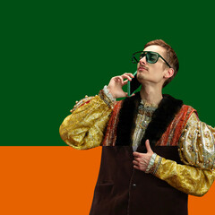Man dressed in mix of Renaissance nobleman opulent outfit and modern sunglasses, casually speaking...