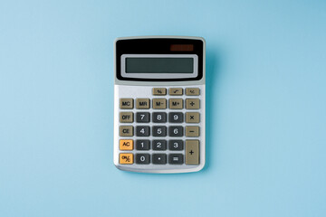 Top view of electronic calculator on blue background