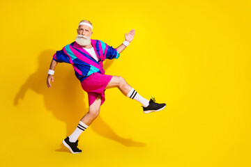 Full length photo of attractive funny retired sportsman retro sportswear enjyoing jogging emtpy space isolated yellow color background