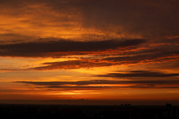 Dramatic panorama of colourful cloud formations in a vast sky - orange sunset