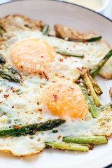 Fried eggs with asparagus and grated cheese. Breakfast concept.