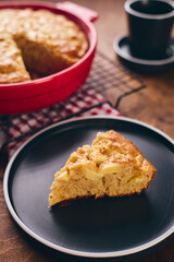 Slice of homemade apple biscuit pie type charlotte on black plate