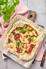 Puff pastry tart pizza with tomatoes, mozzarella cheese and pesto sauce. Galette Caprese
