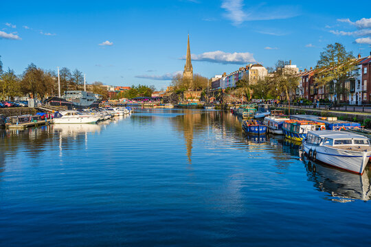 Bristol, England, UK - April 2023: The gothic church of Saint Mary Redcliffe on the shores of river Avon with boats docked in the harbor