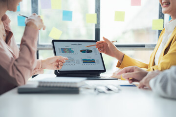 Strategic Business Meeting: Analyzing Charts and Graphs on a Laptop Screen 