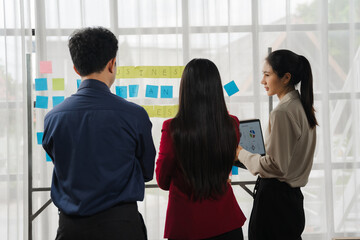 Strategic Collaboration: A diverse team of professionals collaborates on a project, using sticky notes and a digital tablet to brainstorm ideas and strategize.