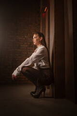 Confident beautiful girl a secretary posing on a metal wall background. Beauty and fashion.