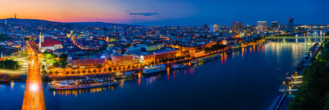 Bratislava, Slovakia - June 2022: City skyline on the shores of the Danube river; Bratislava castle, the old town, Eurovea; UFO bridge; SNP bridge; Appolo Bridge