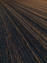 View above plowed field in autumn, ready for sowing. Agricultural landscape. Arable land ready for sowing crops.