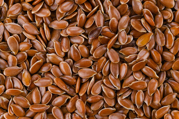 Background of brown flax seeds. Very close macro photography. Top view. Completely in focus.