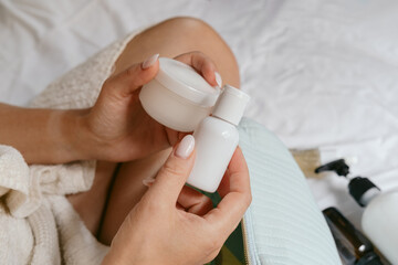 Skin care, Close-up of a woman's hands with manicure holding a white jar of moisturizing or rejuvenating cream