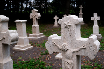 old white crosses and tombstones in a rundown forgotten cemetery in Poland