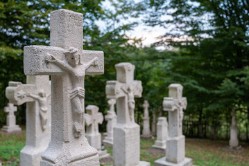 old white crosses and tombstones in a rundown forgotten cemetery in Poland