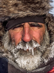 Man's gaze with fur hat and frozen beard