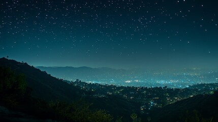 Naklejka premium A serene nighttime view of a cityscape under a starry sky, showcasing urban lights and distant mountains.