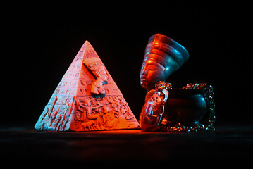 Egyptian pyramid and bust of queen Nefertiti on the dark background.