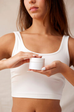 Woman holding skincare product in concise composition