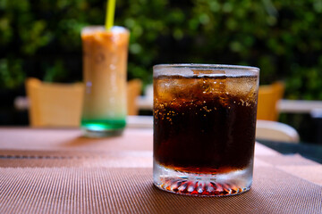 close up of a glass of cola with ice cubes