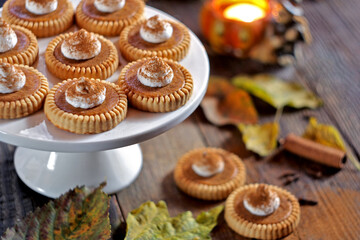 Mini pumpkin pies on a wooden background. Selective focus.