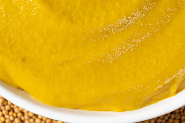 Mustard sauce and dry mustard seeds, top view.
