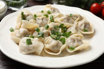 Delicious pelmeni with green onion on table, closeup