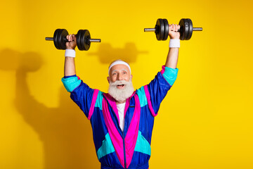 Photo portrait banner of funny senior sportsman lifting dumbbells dressed stylish retro sport costume isolated on yellow color background