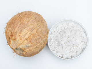 Grated coconut or flakes with whole coconut fruit on white background