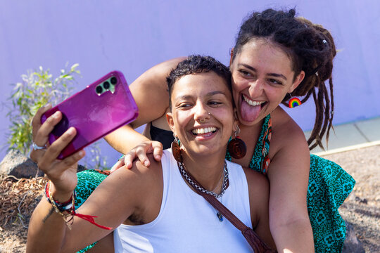 Lesbian couple taking selfie with joyful expressions