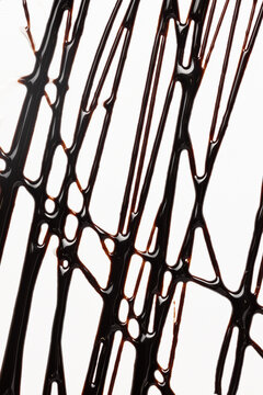 Drizzled chocolate syrup in a vertical pattern on white background