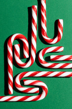 Candy canes on green backdrop captured from above
