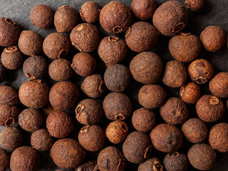 A close-up of black allspice, highlighting the texture and rich color