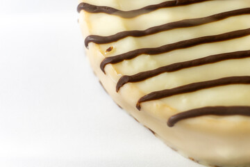 Close-up of a cake with smooth white frosting, drizzled with thin chocolate stripes. Rich texture and elegant design, perfect for dessert themes or bakery-related visuals.
