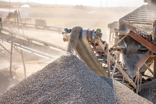 Crushing stones in a quarry for processing minerals, cement, limestone. Distribution and Screening Plant Gravel. Vibrating screen stone crusher in operation.