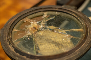 Broken glass on a compass or porthole on a wartime ship. Reflected, distorted and refracted light.